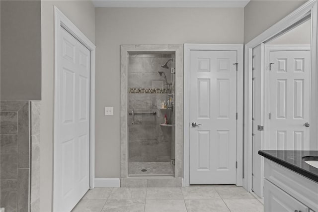 full bathroom with a shower stall, baseboards, and vanity