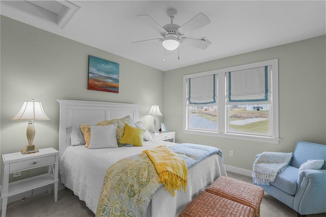 carpeted bedroom with baseboards, ceiling fan, and attic access
