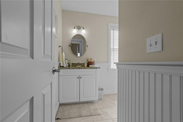 bathroom with a wainscoted wall and vanity