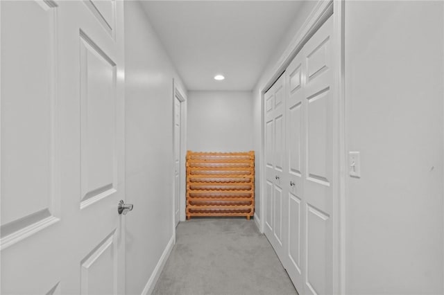 hallway with baseboards, recessed lighting, and light carpet