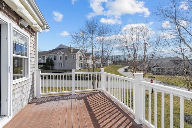 wooden deck featuring a residential view and a yard