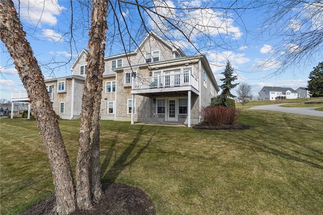 rear view of house featuring a wooden deck and a yard