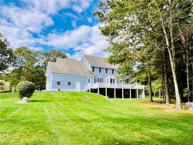rear view of property featuring a lawn and a wooden deck