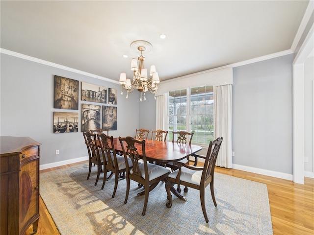 dining room featuring an inviting chandelier, light wood-style floors, ornamental molding, and baseboards
