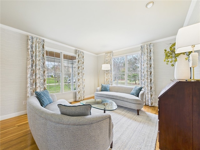 living area featuring baseboards, wood finished floors, a wealth of natural light, and crown molding