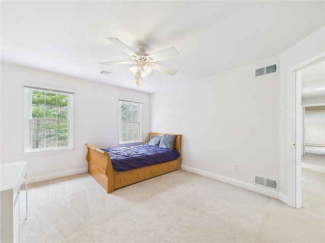 carpeted bedroom featuring visible vents and multiple windows