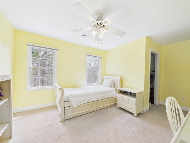 bedroom featuring visible vents, baseboards, a ceiling fan, and light carpet