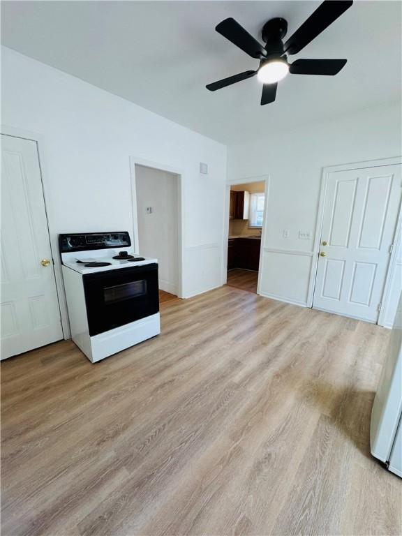 kitchen with a ceiling fan, range with electric stovetop, and light wood-type flooring