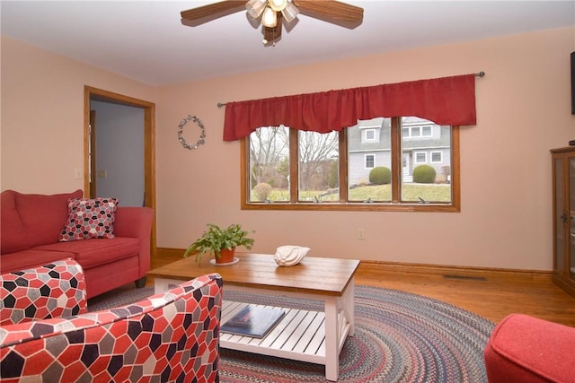 living room featuring visible vents, wood finished floors, and ceiling fan