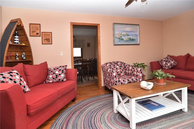 living area with wood finished floors and a ceiling fan