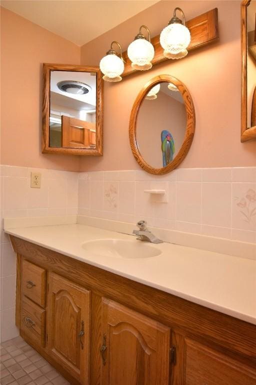bathroom featuring tile walls, a wainscoted wall, tile patterned floors, and vanity