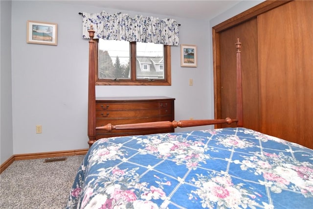 carpeted bedroom with a closet and baseboards