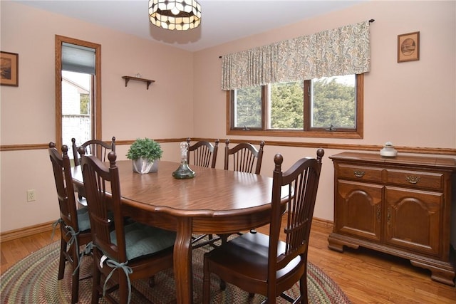 dining area with baseboards, plenty of natural light, and light wood finished floors