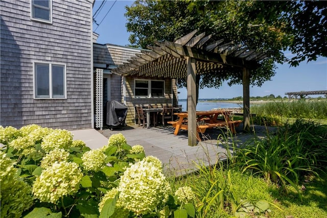 view of patio featuring a deck with water view and a pergola