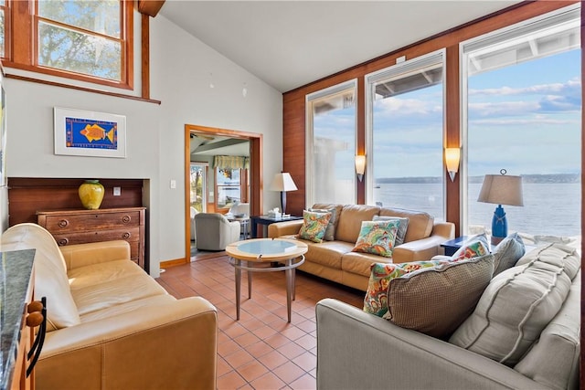 living room featuring light tile patterned flooring, a water view, and high vaulted ceiling