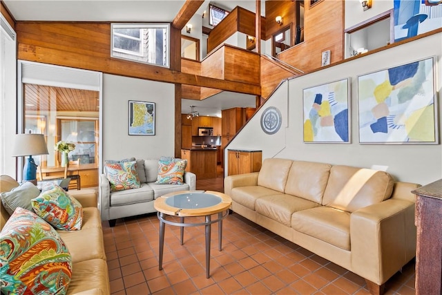living area featuring a high ceiling and dark tile patterned flooring