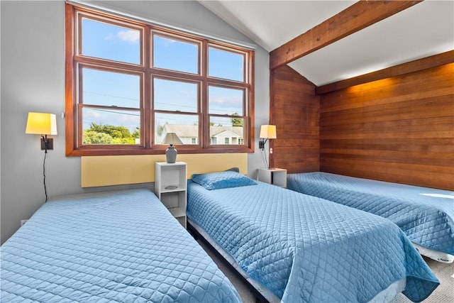carpeted bedroom featuring wooden walls, multiple windows, and vaulted ceiling with beams