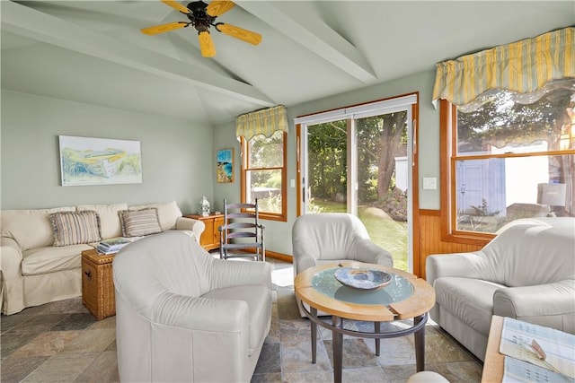 living room with a ceiling fan, wainscoting, vaulted ceiling with beams, and stone finish flooring