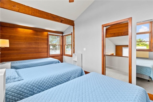 bedroom with multiple windows, vaulted ceiling with beams, and carpet