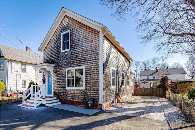 view of front of house with driveway and fence