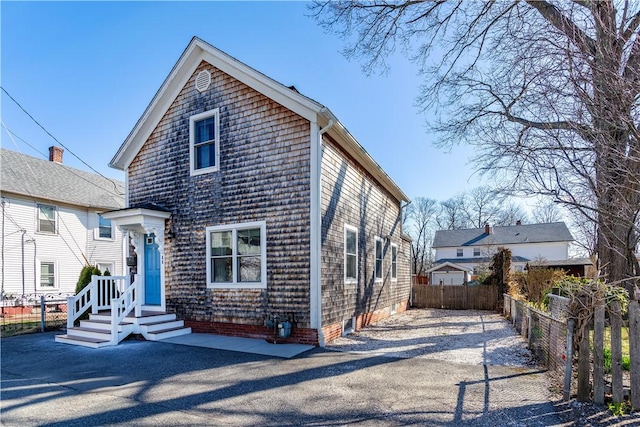 view of front of home featuring aphalt driveway and fence