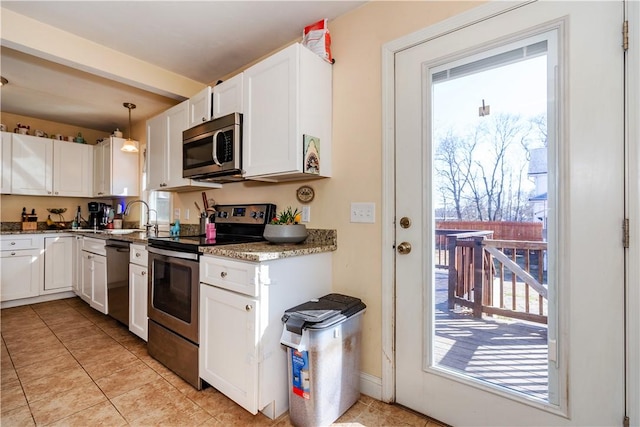 kitchen with light tile patterned floors, white cabinets, a sink, and stainless steel appliances