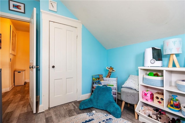 recreation room featuring baseboards, vaulted ceiling, and wood finished floors