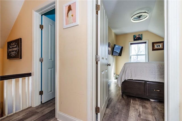 corridor with vaulted ceiling and wood finished floors