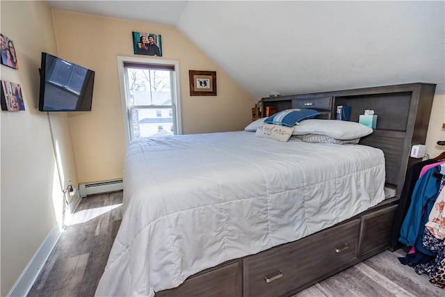 bedroom with baseboards, lofted ceiling, wood finished floors, and a baseboard heating unit