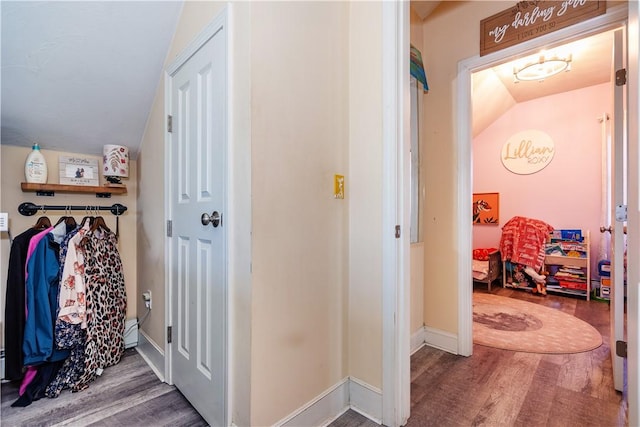 interior space with baseboard heating, baseboards, and wood finished floors