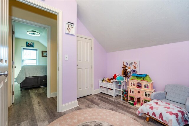 playroom featuring baseboards, lofted ceiling, and wood finished floors