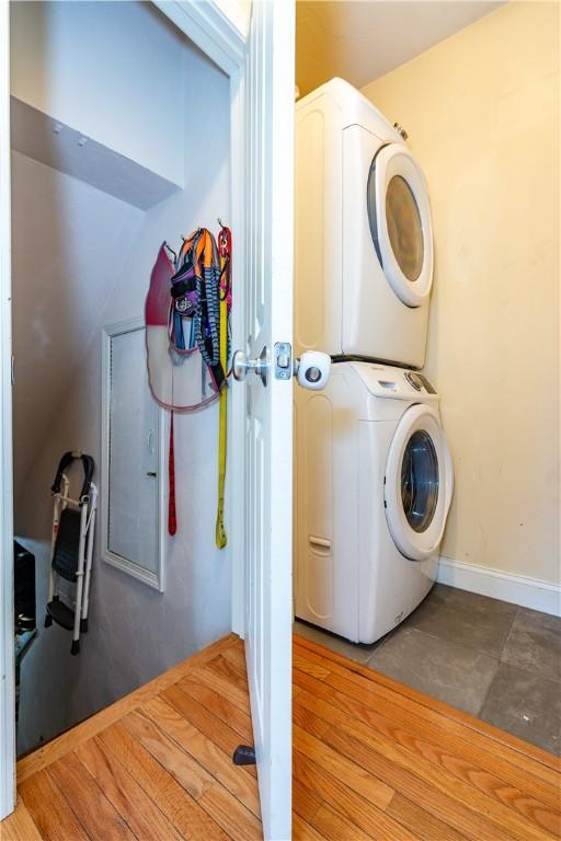 laundry room featuring baseboards, stacked washer / drying machine, and laundry area