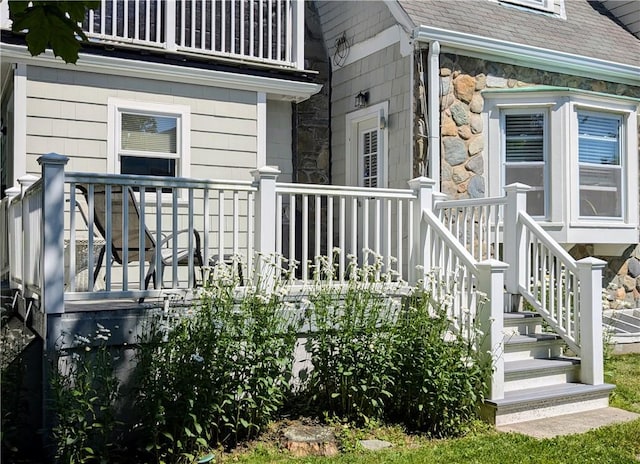 23 Smith Ave Unit 2, Newport, RI 02840 - view of exterior entry with a shingled roof, a balcony, and stone siding