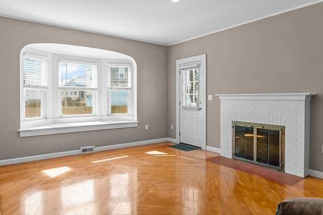 23 Smith Ave Unit 2, Newport, RI 02840 - unfurnished living room with baseboards, visible vents, wood finished floors, and a fireplace