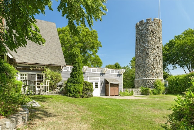 back of house with an outdoor structure and a yard