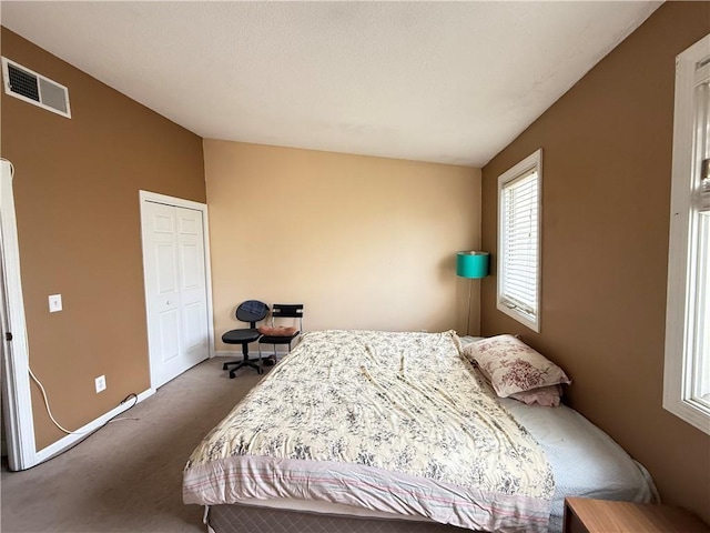 carpeted bedroom with baseboards, visible vents, and vaulted ceiling