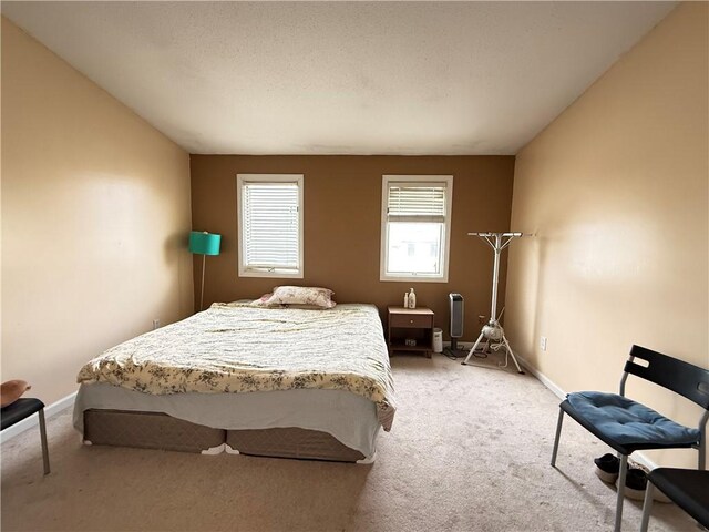 bedroom featuring light carpet and baseboards