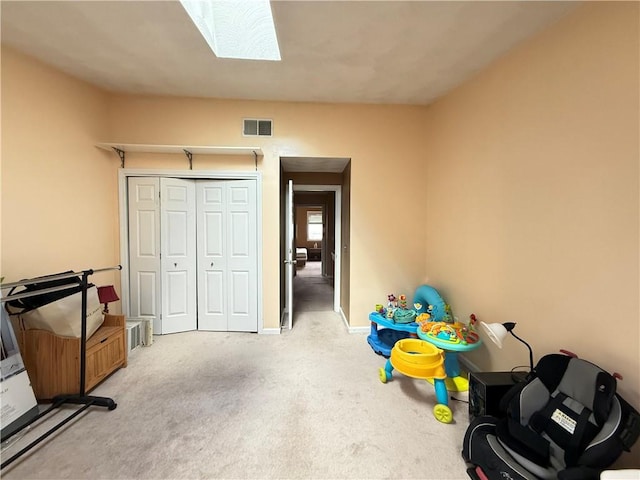 rec room featuring light carpet, a skylight, baseboards, and visible vents