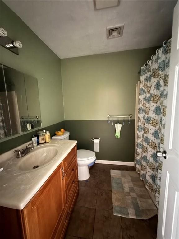 bathroom with toilet, vanity, tile patterned flooring, baseboards, and visible vents