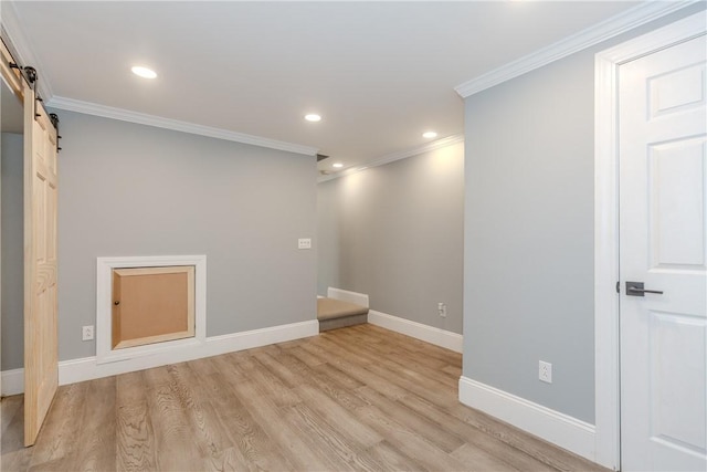 below grade area with crown molding, baseboards, recessed lighting, a barn door, and light wood finished floors