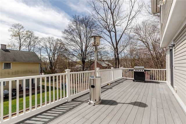 wooden terrace with a lawn and grilling area