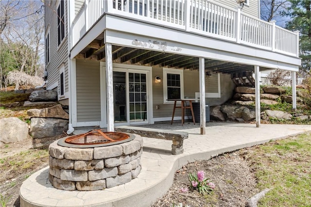 exterior space featuring a wooden deck, a patio, and a fire pit