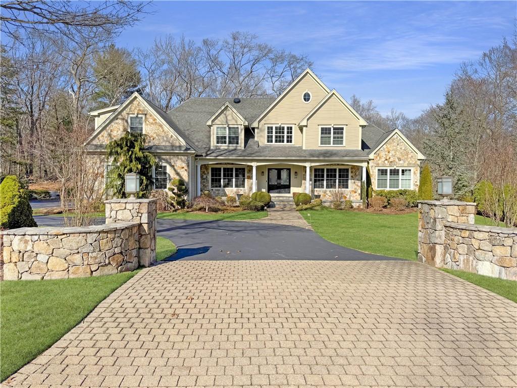 20 Beechcrest Rd, East Greenwich, RI 02818 - view of front of house featuring a front lawn, stone siding, driveway, and a porch