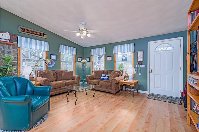 living room featuring a wealth of natural light, lofted ceiling, wood finished floors, and ceiling fan