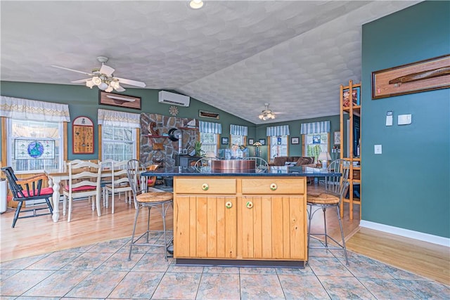 kitchen featuring ceiling fan, dark countertops, and a kitchen breakfast bar