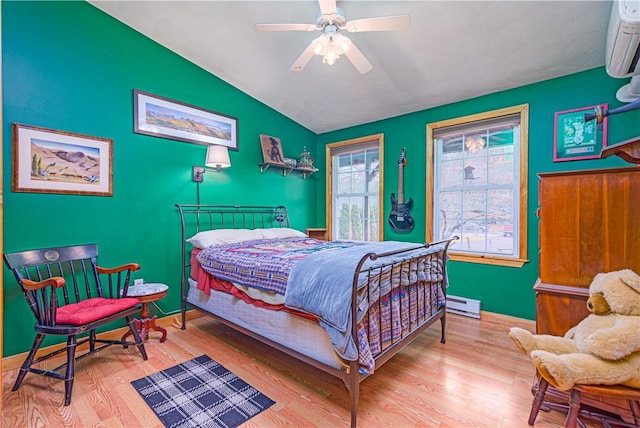 bedroom with a baseboard radiator, baseboards, vaulted ceiling, and wood finished floors