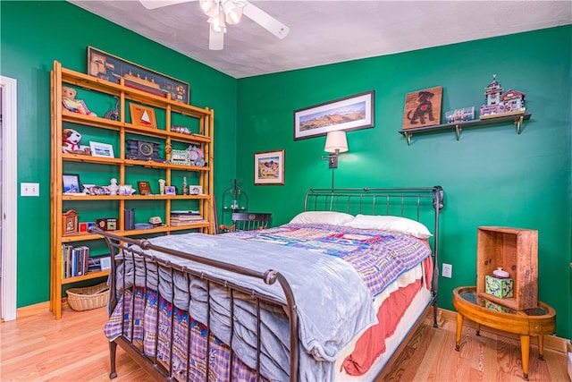bedroom with baseboards, ceiling fan, and wood finished floors