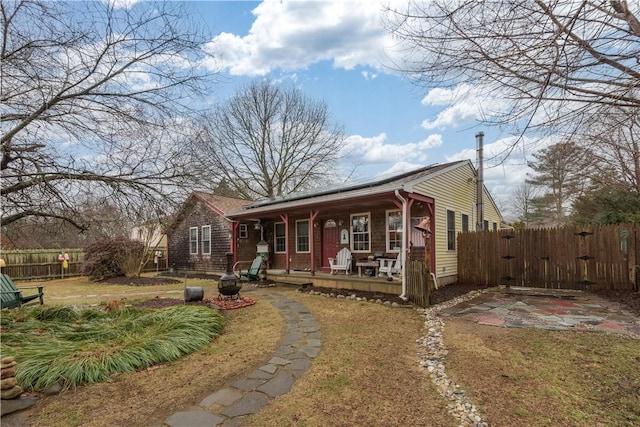 view of front of house with covered porch, a gate, and fence