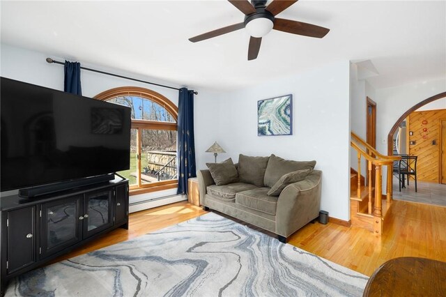 135 Eagleville Rd, Tiverton, RI 02878 - living room with arched walkways, light wood-style floors, a ceiling fan, and stairs