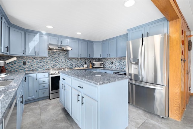135 Eagleville Rd, Tiverton, RI 02878 - kitchen featuring stainless steel appliances, under cabinet range hood, light stone countertops, a center island, and backsplash